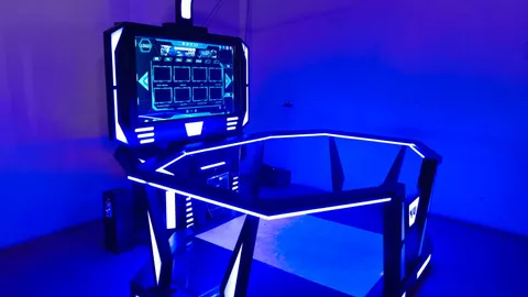 Gaming desk with glowing blue LED edges and a mounted screen in a blue-lit room