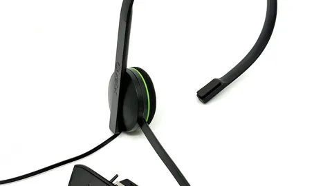 Black single-ear chat headset with a boom microphone and an inline controller adapter