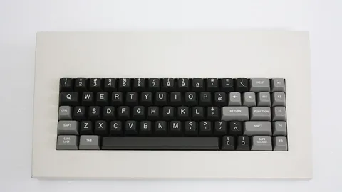 Compact mechanical keyboard with grey and black keycaps on a white background