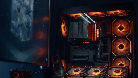 Gaming PC setup with an open case and RGB lighting on a desk at night