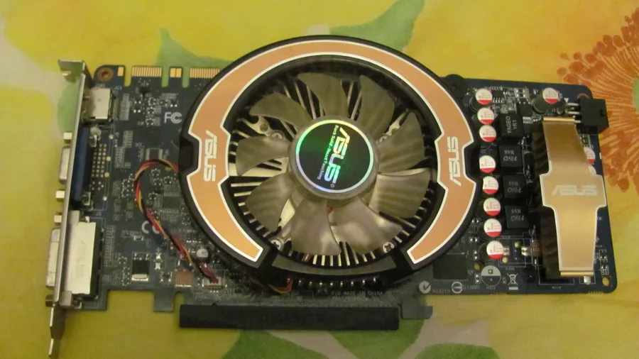 Graphics card with a large round cooling fan lying on a patterned cloth