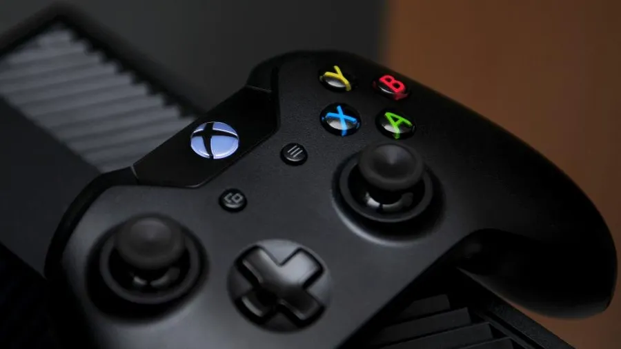 Close-up of a black Xbox controller with colored face buttons