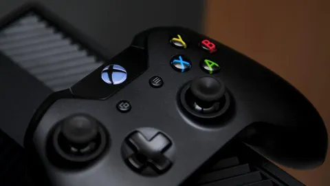 Close-up of a black Xbox controller with colored face buttons