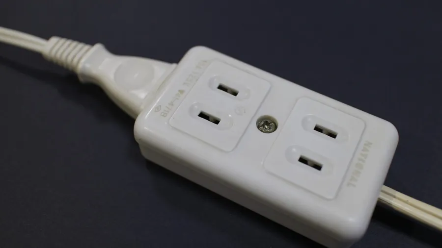 White power strip with four outlets on a dark surface