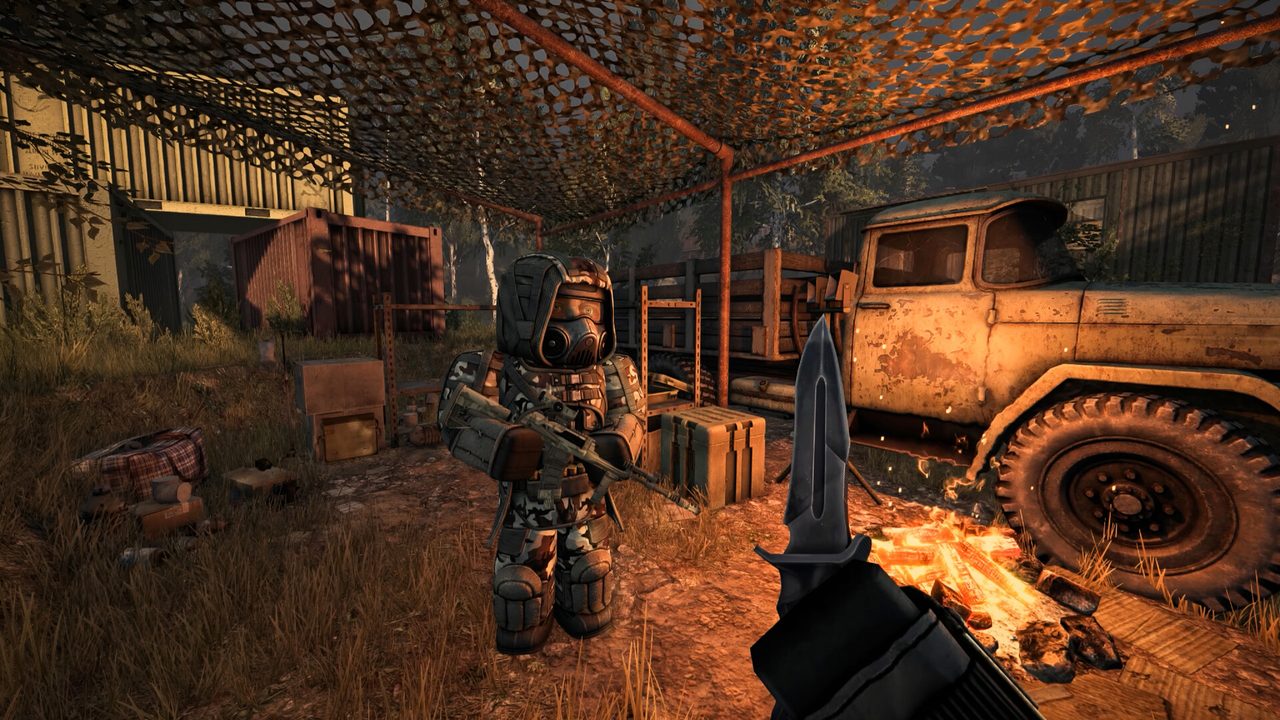 Armed STALZONE player kneeling beside a rusted truck under a corrugated shelter
